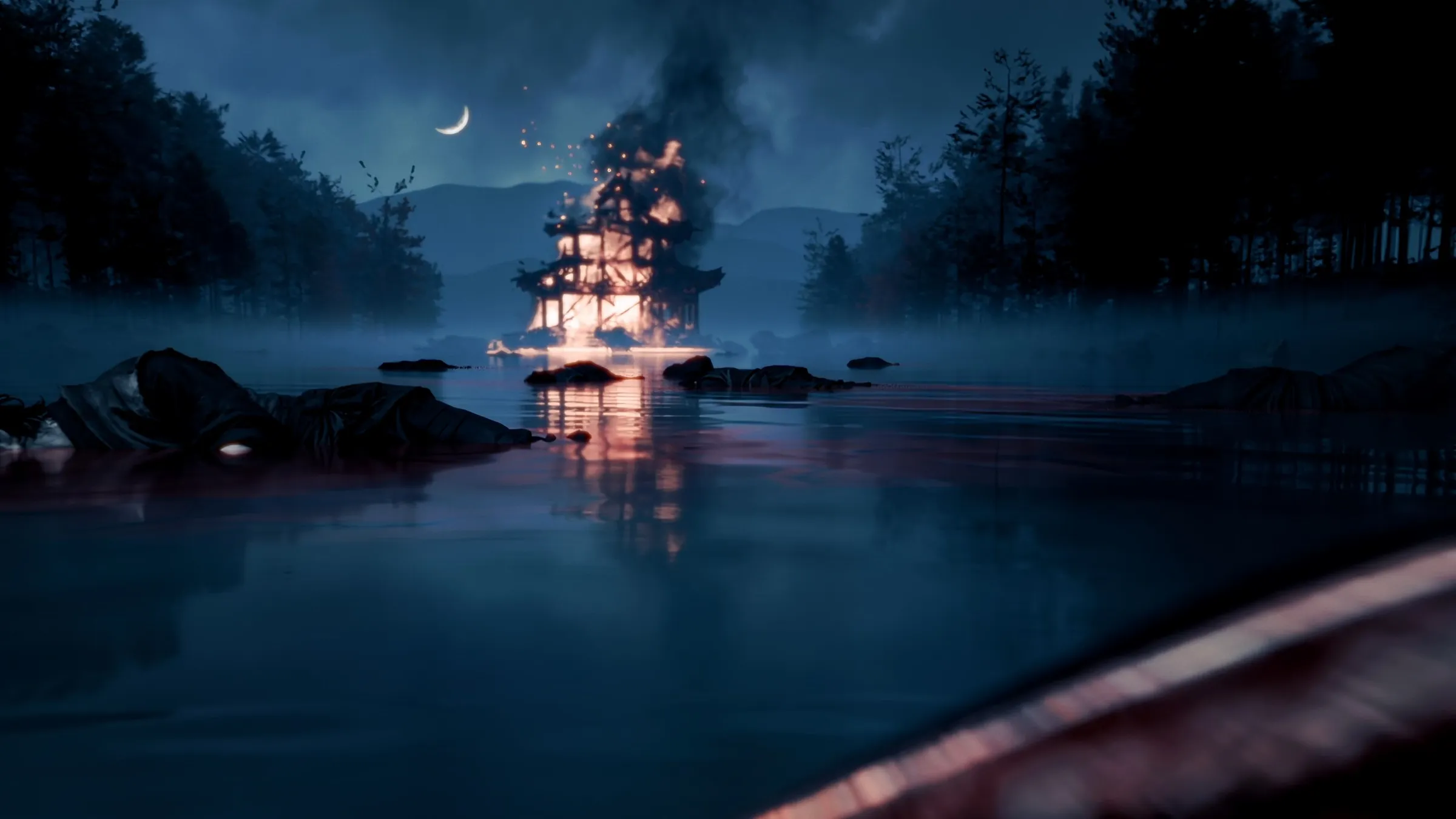 A burning pagoda on a still lake at night, reflected in the water, with rocks in the foreground.