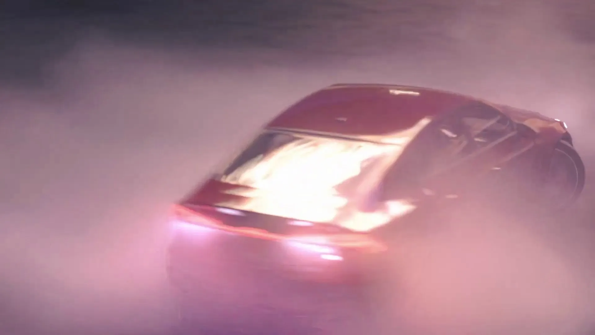 The red Audi seen from above sliding through thick pink smoke.