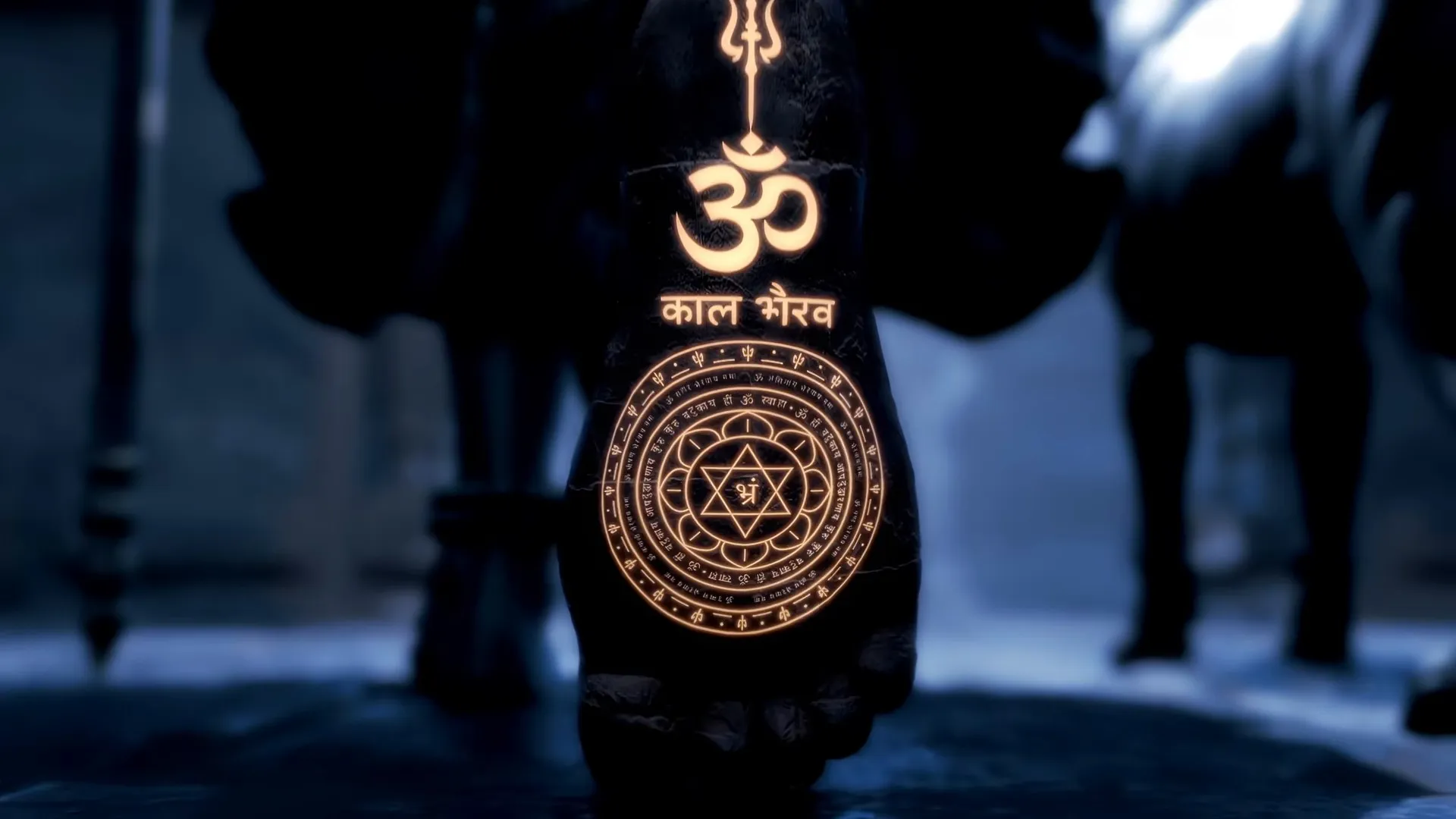 Kaal Bhairav's bronze yantra pendant engraved with a trishul, Om and his name, hanging between the temple dog and his staff.